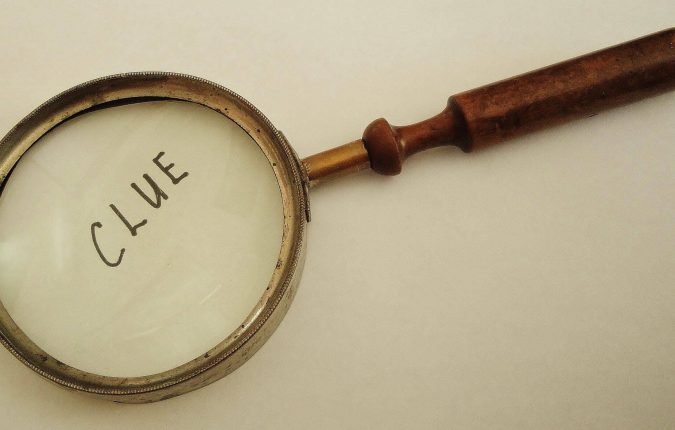 A vintage and well used Magnifying Glass magnifies the word "Clue".